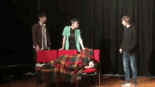 a group of young men are playing a game on a stage and one of them is holding a microphone .