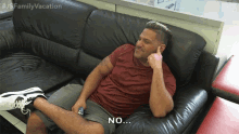 a man is sitting on a couch with the word no on his face