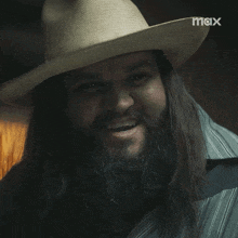 a man with long hair and a beard wearing a cowboy hat with max written on the bottom