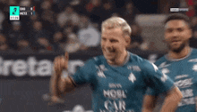 a soccer player wearing a mosc car avenue jersey celebrates a goal