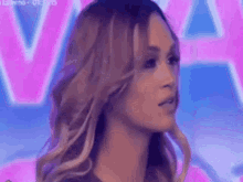 a close up of a woman 's face in front of a pink and blue background .