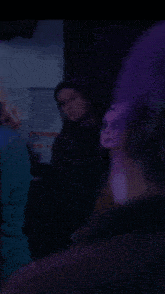 a blurry picture of a group of people in a dark room with purple lights