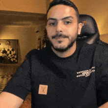 a man wearing a black shirt that says louis vuitton