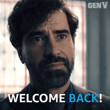 a man with a beard is looking at the camera and says welcome back