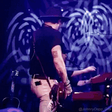 a man with a tattoo on his arm playing a guitar on stage