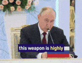 a man in a suit and tie is speaking into a microphone with the words this weapon is highly behind him