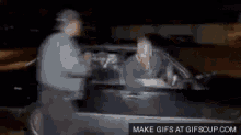 a man is pointing a gun at a woman in a car