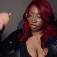 a woman with red hair wearing glasses and a nose ring