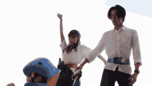 a man and a woman standing next to a stuffed animal with a belt that says ' samurai ' on it
