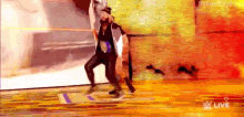 a man and a woman are dancing on a stage in front of a wall .