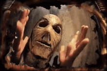 a person with a mask on their face is reaching out their hands .