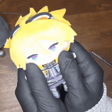 person wearing black gloves holding a stuffed toy
