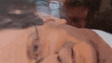 a close up of an elderly man 's face with glasses laying on a bed .