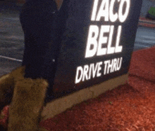 a taco bell drive thru sign with a teddy bear 's paws on it