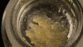a close up of a glass with a yellow substance inside of it