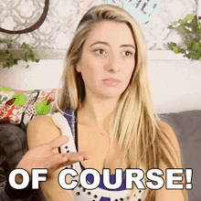 a blonde woman is sitting on a couch with the words of course written on her chest