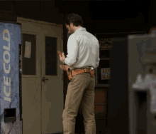 a man is standing in front of a vending machine that says ice cold