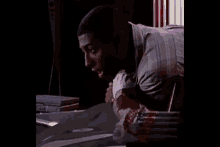 a man is laying on a table with a reflection of his face on the table
