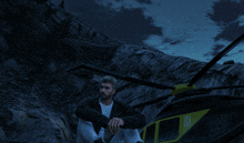 a man sits in front of a helicopter with a k on the side