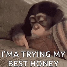 a chimpanzee is laying on a bed with its eyes closed and pointing at something .