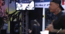 a man in a baseball cap is standing in front of a sign that says ' kings of ' on it .