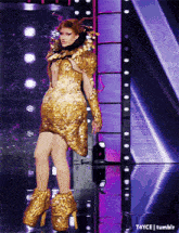 a woman in a gold dress is standing on a stage with t4yce tumblr written on the bottom