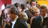 a group of people standing in a room with a red door