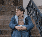 a man sits on the steps of a building with his legs crossed