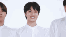 a group of young men wearing white shirts are smiling