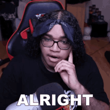 a man wearing glasses and a bandana has the word alright written on his face