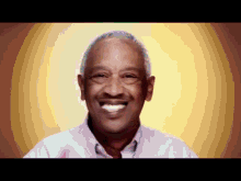 a man with gray hair and a white shirt smiles for the camera