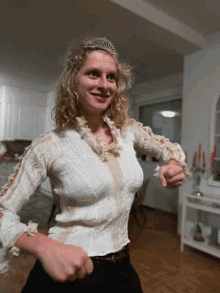 a woman wearing a tiara and a white top is dancing