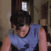 a man wearing a blue shirt with a mickey mouse on it is sweating .