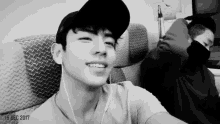 a black and white photo of a man wearing a hat and earbuds
