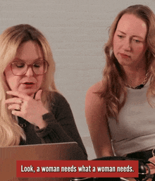 two women are sitting in front of a laptop with the words look a woman needs what a woman needs