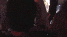 a blurry picture of people dancing in a dark room .