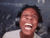 a man wearing headphones is making a funny face while screaming .