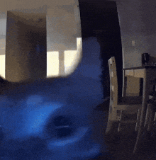 a room with a table and chairs and a blue smoke coming out of the window