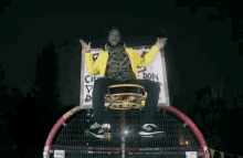 a man in a yellow jacket is riding a ferris wheel at night .