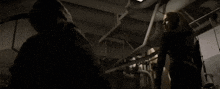 a person is standing in a dark room with a bunch of tools on the wall .