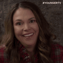 a woman is smiling with the #youngertv logo behind her
