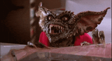 a close up of a gremlin looking over a table .