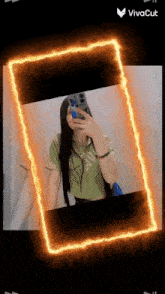 a girl is taking a picture of herself in a mirror with a fire frame around her .