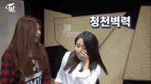 two girls laughing in front of a sign that says jup entertainment
