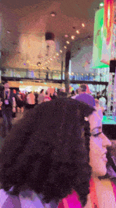 a woman with curly hair is standing in front of a crowd