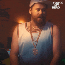 a man with a beard is wearing a hat and a necklace with a dollar sign pendant