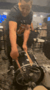 a man in a rolling stones shirt is playing a drum
