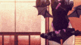 a girl with bat wings is standing in front of a window