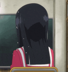 a girl with long black hair is sitting in front of a chalkboard