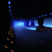 a car is driving through a dark tunnel with a blue light